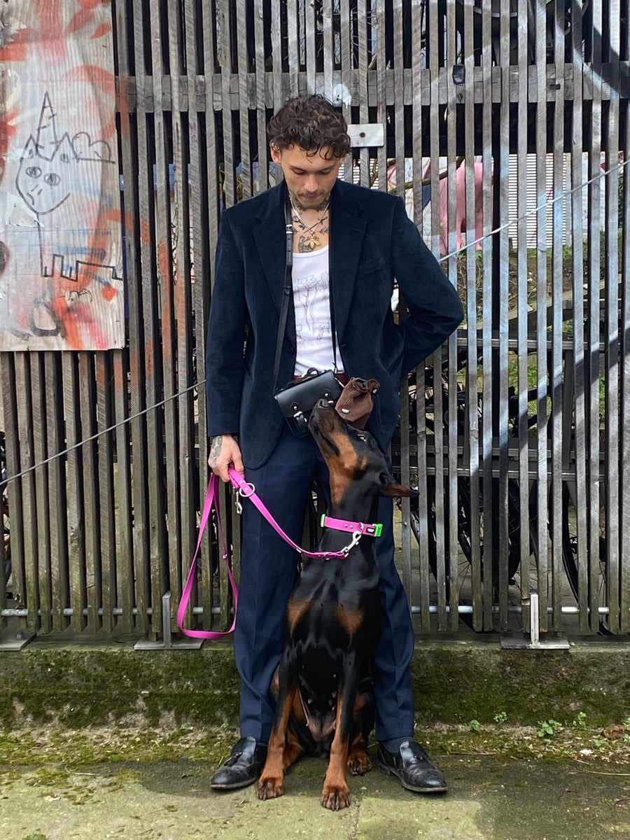 Männliches Model mit Dobermann, der Hund trägt ein veganes Set aus Halband und Leine in lila und neongrün on SUNNY BERLIN