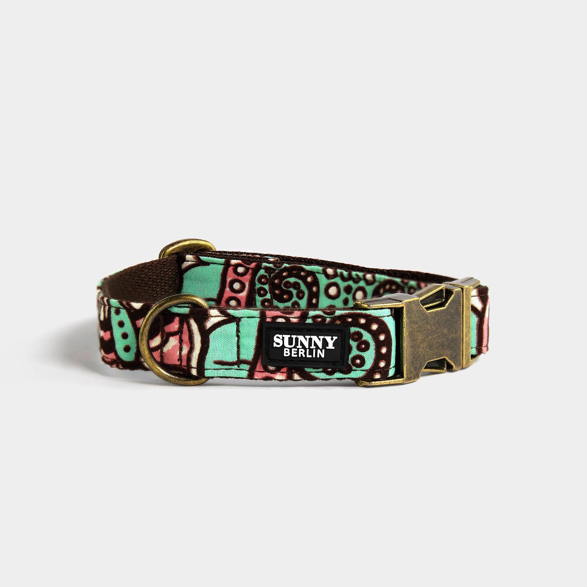 Hundehalsband von Sunny Berlin mit traditionell afrikanischem Muster in türkis, braun, weiß und rosa von. Die Metallteile sind in Antik Optik