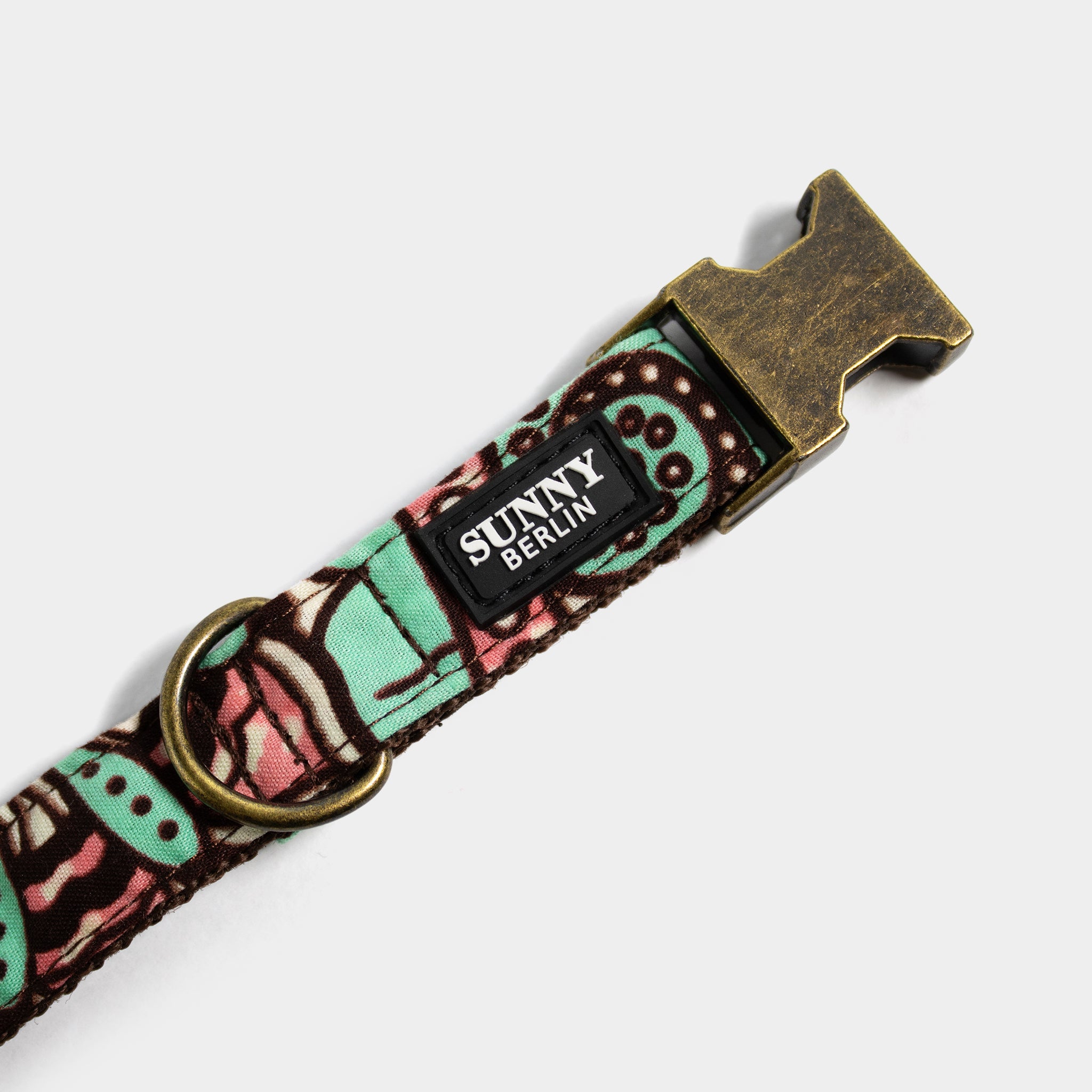 Hundehalsband von Sunny Berlin mit traditionell afrikanischem Muster in türkis, braun, weiß und rosa von. Die Metallteile sind in Antik Optik