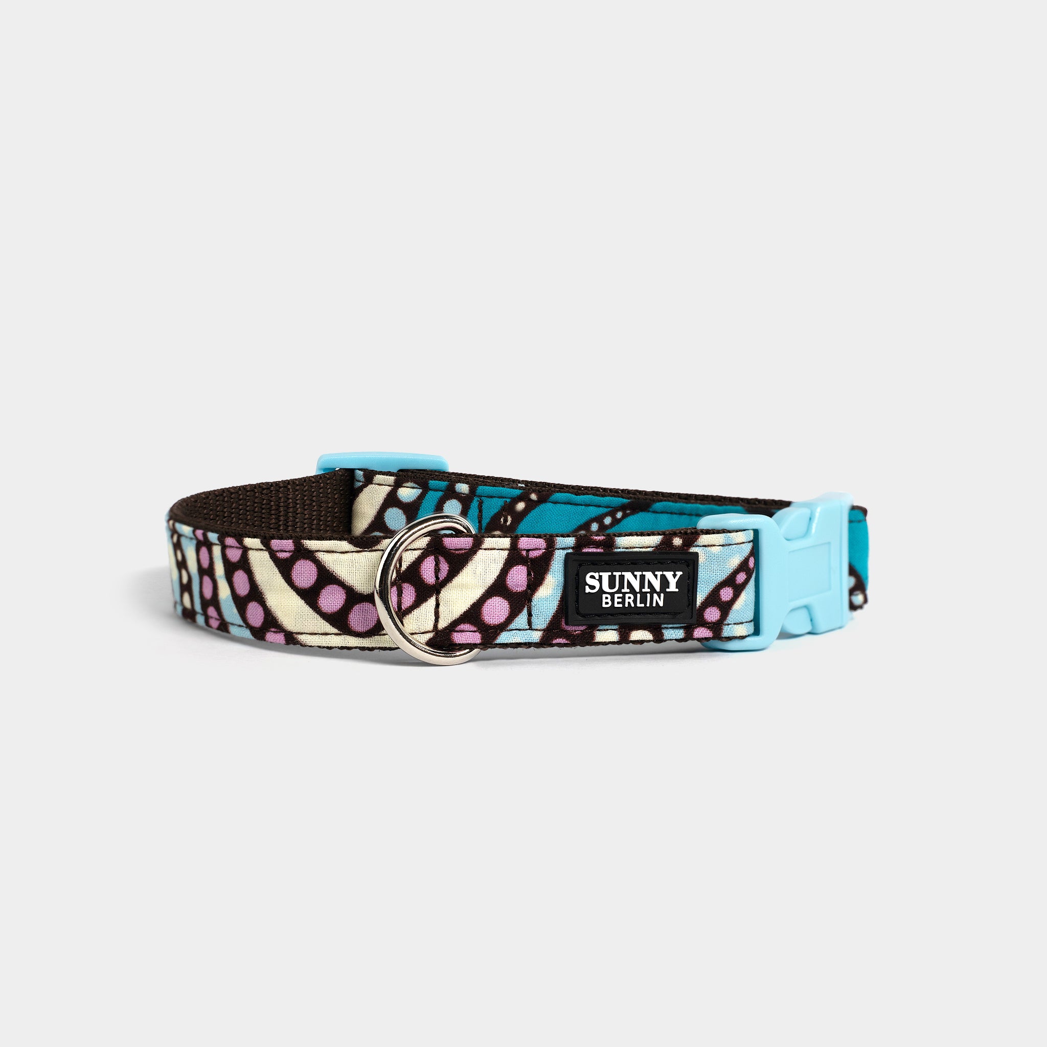 Hundehalsband von Sunny Berlin mit traditionell afrikanischem Muster in türkis braun, rosa und weiß. Verschluss aus Kunststoff in hellblau.