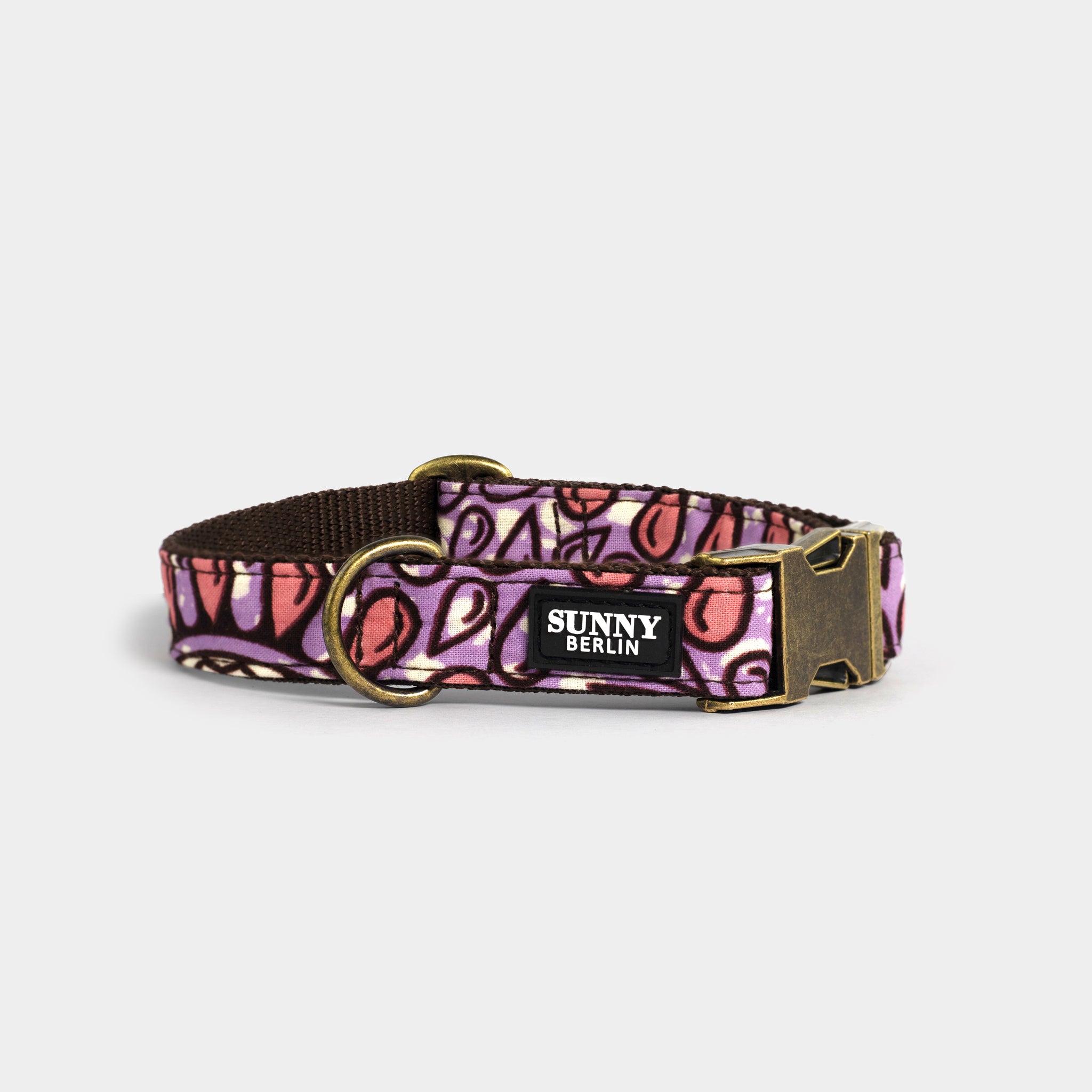 Hundehalsband von Sunny Berlin mit traditionell afrikanischem Muster in braun, weiß, lila und rosa. Die Metallteile sind in Antik Optik