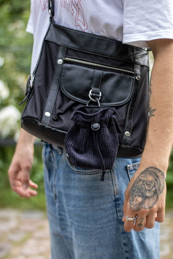 Männliches Model mit Tasche, an dieser ist ein schwarzer Cord Leckerlibeutel von SUNNY BERLIN befestigt.